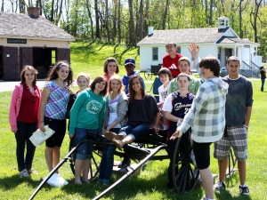 Group of kids around Amish wagon