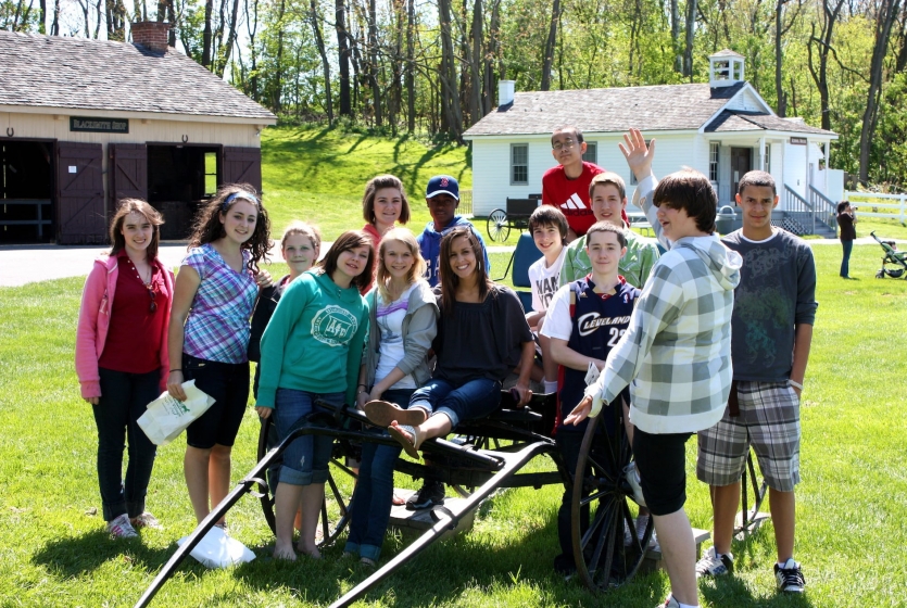 Group of kids around Amish wagon