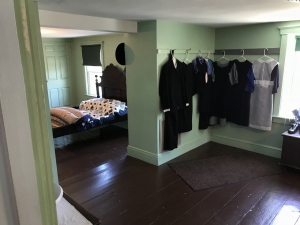 Amish suits and dresses hanging in an Amish bedroom