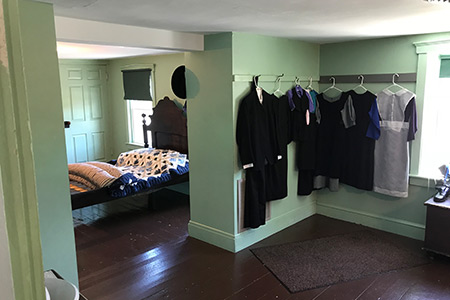 Clothing hanging in an Amish bedroom