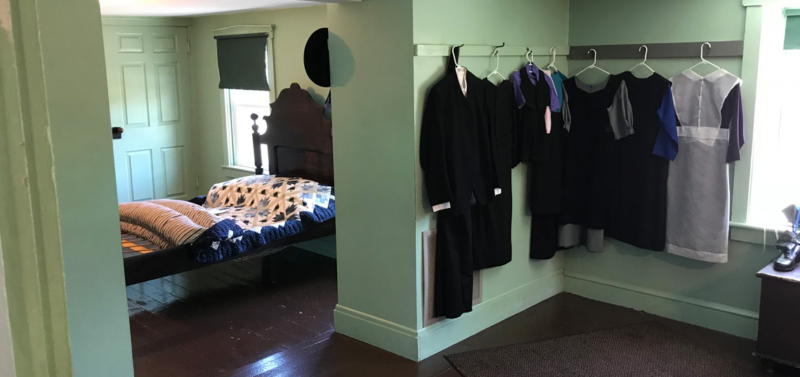 Clothing hanging in an Amish bedroom