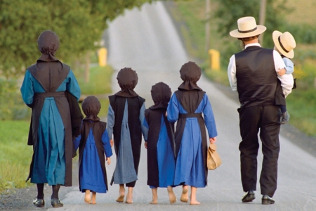 An Amish family walking on a country road