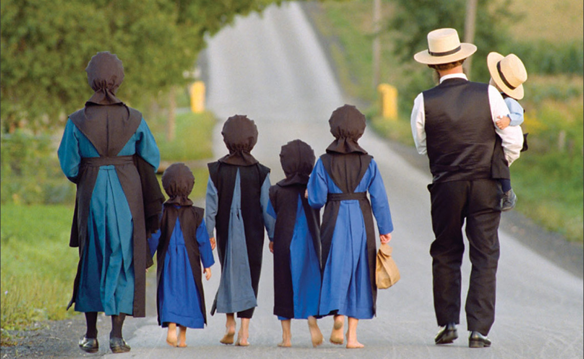 An Amish family walking on a country road