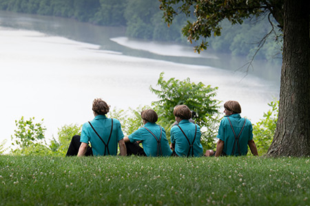 Amish boys sitting by the riverfront